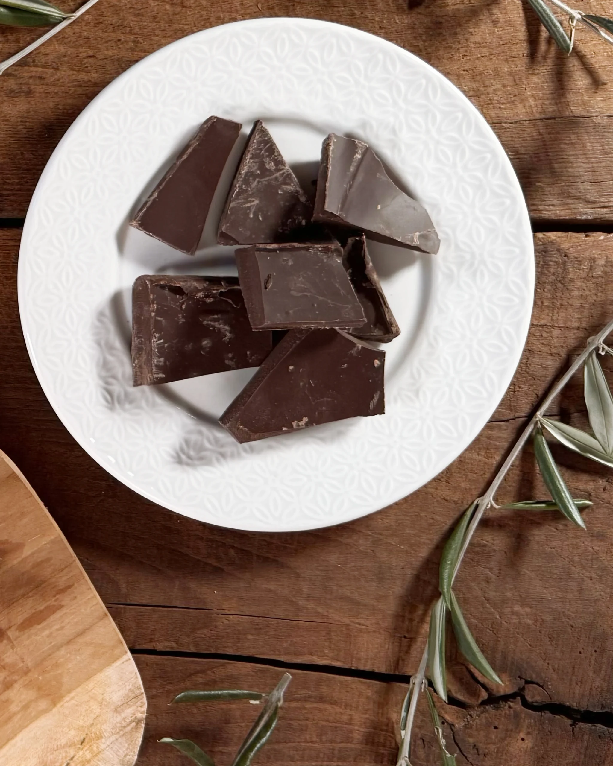 Piatto con pezzetti di uovo di cioccolato fondente e ulivo.
