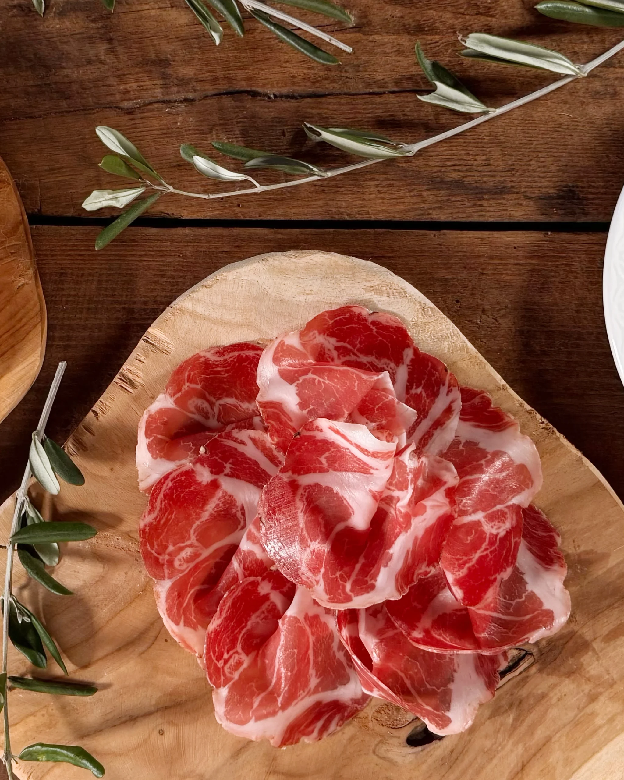 Coppa Piacentina su tagliere con ulivo per tavolata di Pasqua.