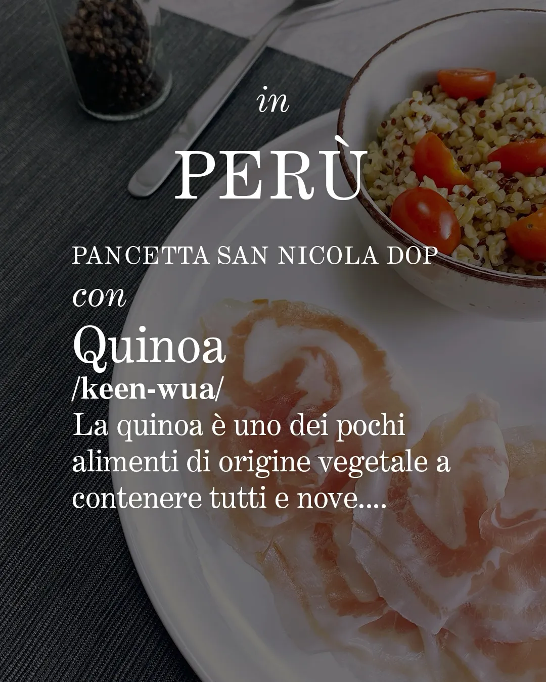 Piattino di quinoa con pomodori datterini sopra un piatto più grande con adagiate sopra le fette di Pancetta San Nicola DOP. A fianco una forchetta e del pepe nero su una tovaglietta grigia. Scritte in primo piano.